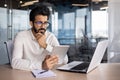 Concentrated and serious young Indian man working in office at desk with tablet Royalty Free Stock Photo