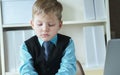 Concentrated small boy in suit thinking about money and budget increasing ways. Little financial director.