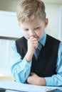 Concentrated small boy in suit thinking about money and budget increasing ways. Little financial director.