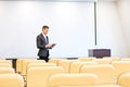 Concentrated speaker repeating speech with tablet in empty boardroom