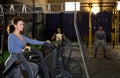 Concentrated woman working out on stationary air bicycle in gym Royalty Free Stock Photo