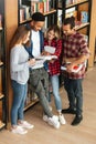 Concentrated students standing in library reading book. Royalty Free Stock Photo