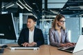 Team of business partners working together on computer and laptop, Asian man and woman in a modern office Royalty Free Stock Photo