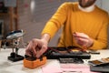 Concentrated technician busy repairing laptop at workshop using multimeter. Concept of skill jobs and repair service.