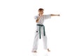 Concentrated teen boy, karate practitioner in defensive stance, showcasing focus and readiness, practicing isolated on