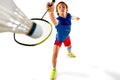 Concentrated teen boy in uniform playing badminton, hitting shuttlecock with racket isolated over white background Royalty Free Stock Photo