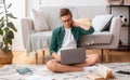 Concentrated teen guy studying at home, using laptop