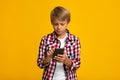 Concentrated teenager european boy typing on smartphone, playing or chatting