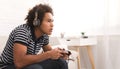 Concentrated teenager playing video games with joystick