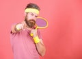 Concentrated on tennis court. Athlete hipster hold tennis racket in hand red background. Tennis sport and entertainment Royalty Free Stock Photo