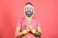Concentrated on tennis court. Athlete hipster hold tennis racket in hand red background. Man bearded hipster wear sport Royalty Free Stock Photo