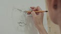 Concentrated woman artist painting classical man portrait with pencil Royalty Free Stock Photo