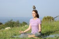 Concentrated woman doing yoga with a owlet on head