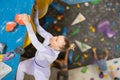 Concentrated woman moving up bouldering wall in climbing gym Royalty Free Stock Photo