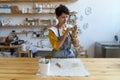 Female potter painting on clay jug in workshop, working in pottery studio. Hobby, small business. Royalty Free Stock Photo