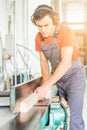 Concentrated woodworker trimming wooden plank in workshop