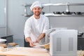 Concentrated at work. Handsome chef rolling a dough through pasta machine Royalty Free Stock Photo
