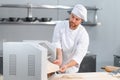 Concentrated at work. Handsome chef rolling a dough through pasta machine Royalty Free Stock Photo