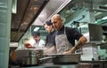 Concentrated at work. Professional team of chef and two young assistants cooking in a restaurant kitchen Royalty Free Stock Photo