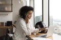 Concentrated young african american businesswoman multitasking in office.