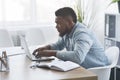 Concentrated young african worker using laptop in office