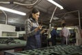 Concentrated young artisan holding leather pieces in shoemaking workshop