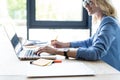 Concentrated young beautiful businesswoman working on laptop in bright modern office. Royalty Free Stock Photo