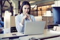 Concentrated young beautiful businesswoman working on laptop in bright modern office. Royalty Free Stock Photo