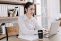 Concentrated young beautiful businesswoman working on laptop in bright modern office,Work from home concept Royalty Free Stock Photo