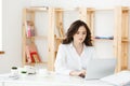 Concentrated young beautiful businesswoman working on laptop and document in bright modern office Royalty Free Stock Photo