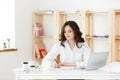 Concentrated young beautiful businesswoman working on laptop and document in bright modern office Royalty Free Stock Photo