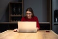 Concentrated young beautiful businesswoman working on laptop in modern home office. Expert female finishing her job for internet Royalty Free Stock Photo