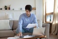 Concentrated young businessman doing paperwork using home office computer Royalty Free Stock Photo