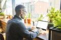 Concentrated young businessman in eyewear looking at laptop computer screen. Royalty Free Stock Photo