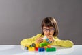 Concentrated young child playing with building blocks and career engineer
