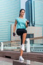 Concentrated young female athlete doing jump step ups exercise on bench on city street. Royalty Free Stock Photo