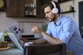 Concentrated young freelancer businessman using laptop for video conferance, working remotely online at home