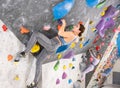 Concentrated young girl climbing on bouldering wall in gym Royalty Free Stock Photo