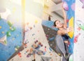 Concentrated young girl climbing on bouldering wall in gym Royalty Free Stock Photo