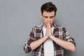 Concentrated young man praying with closed eyes