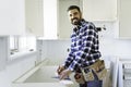 Concentrated young man work with white cabinet in the kitchen Royalty Free Stock Photo