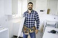 Concentrated young man work with white cabinet in the kitchen Royalty Free Stock Photo