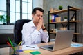 Concentrated young manager man sitting at office desk working on laptop computer and thinking about solving a financial problem Royalty Free Stock Photo