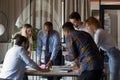 Concentrated young mixed race teammates analyzing paper reports. Royalty Free Stock Photo