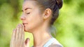 Concentrated young woman blonde meditates in yoga pose joining hands in namaste asana Royalty Free Stock Photo