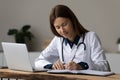 Concentrated young woman medical worker take notes at workplace Royalty Free Stock Photo