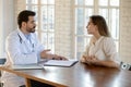 Concentrated young woman patient visiting doctor general practitioner Royalty Free Stock Photo