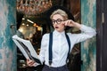 Concentrated young woman standing and reading magazine in cafe Royalty Free Stock Photo