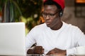 Concentration black hipster male in headphones, eyewear studing or working remotely on computer Royalty Free Stock Photo