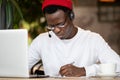 Concentration black hipster male in headphones, eyewear studing or working remotely on computer Royalty Free Stock Photo